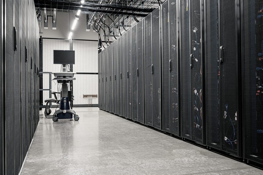 Un pasillo de centro de datos, con racks de servidores y cableado en perspectiva